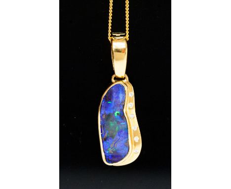 A black opal and diamond set pendant and chain, the irregular shaped polished black opal of a fire blue/green colour approxim