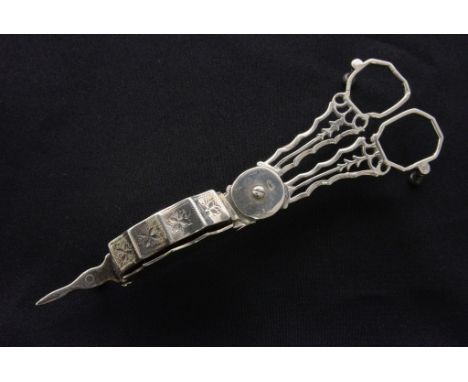 A George III, circa 1790, Irish sterling silver candle snuffer, with bright-cut bands and pierced motifs, standing on three w