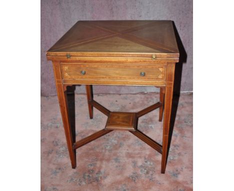 An Edwardian mahogany envelope card table, the top swivelling round to reveal well and opening out to reveal a central leathe