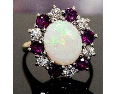 An opal, ruby and diamond cluster ring, the central white precious opal approximately 11mm by 9mm, six rubies and six round b