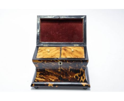 A George III tortoiseshell tea caddy, of rectangular section, ogiform pedestal shape, on ball feet, with white metal stringin