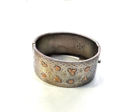 Victorian silver and gold inlaid cuff bangle measures approx 6.5cm by 5.3cm and 3.1cm wide in good condition full Birmingham 