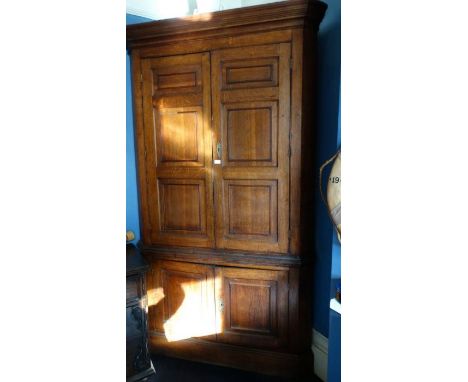 *Item to be collected from Friargate, Derby*A large George III oak floor standing corner cupboard, stepped frieze above a pai