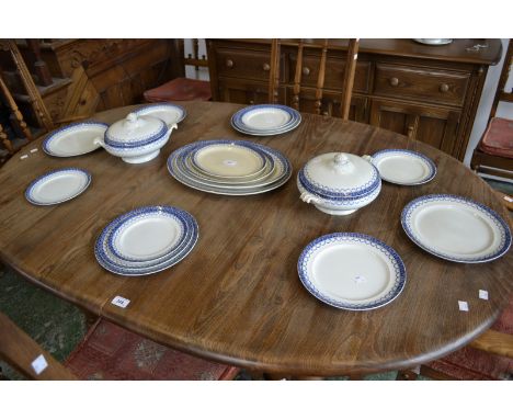 A Staffordshire dinner service, blue border with garlands, comprising vegetable and sauce tureens, graduated service platters