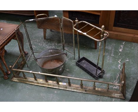 An early 20th century brass fender; a brass stick stand; a brass fire guard; a brass jam pan; a brass poker (5)