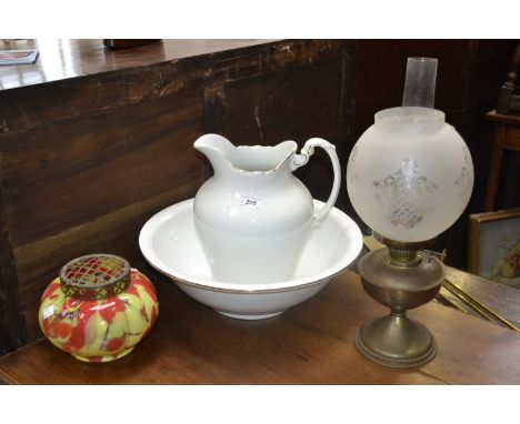 An early 20th century lobed ovoid rose bowl in red and yellow; a Staffordshire wash bowl and pitcher, gold border; an oil lam
