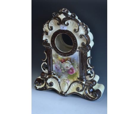 A 19th century Continental ceramic clock case, central cartouche painted with blossoming roses, moulded C-scroll pediment, pi
