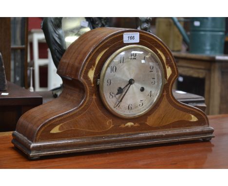 A mahogany inlaid Napoleon hat shaped mantel clock, twin winding holes, Arabic numerals