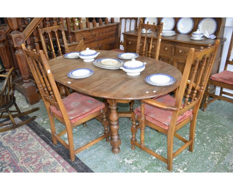 An Ercol Golden dawn extending dining table, D-ends, two spindleback carvers and four conforming dining chairs (7)