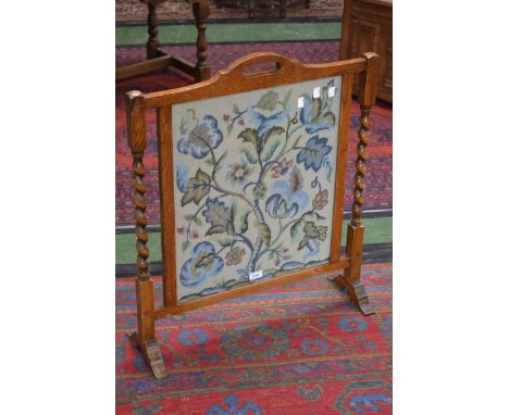A 1940's oak fire screen with barley twist supports 