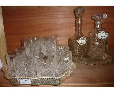 Selection of cut glass drinking glasses on silver plated gallery tray and 2 decanters with ceramic spirit labels