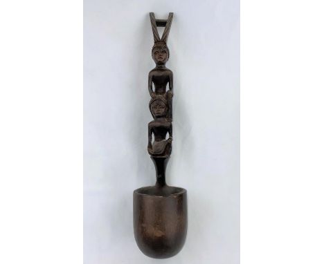 An African carved wood ladle with tall figure handle, 47cm