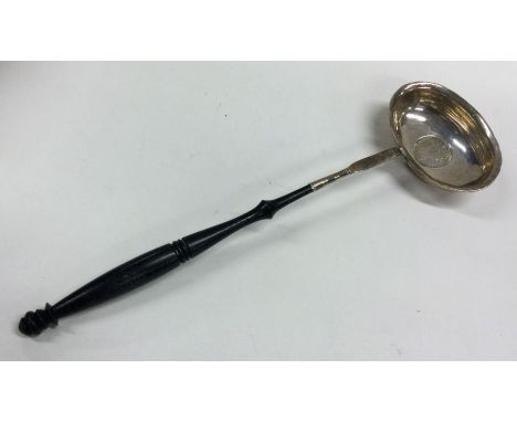 A Georgian silver toddy ladle with coin inset bowl and turned wooden handle. Approx. 43 grams. Est. £30 - £50.