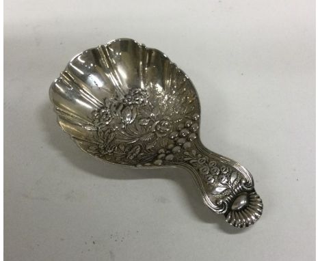 A chased silver caddy spoon decorated with flowers and leaves. Approx. 15 grams. Est. £30 - £50.