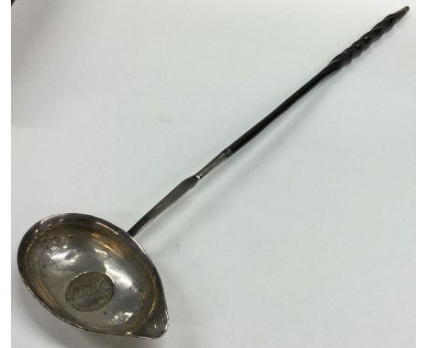 A Georgian silver toddy ladle with coin inset to whalebone handle. Approx. 48 grams. Est. £30 - £50.