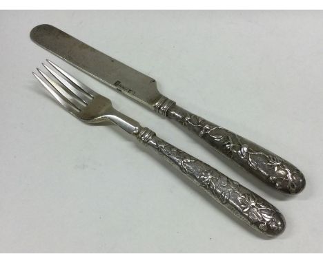 A finely cast Chinese silver knife together with matching fork decorated with scrolls and leaves. Punched to blade. Approx. 1