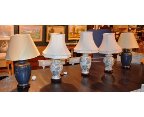 Two pairs of ceramic table lamps, with shades, on blue and white grounds, converted to electricity, 70cm high, and another (5