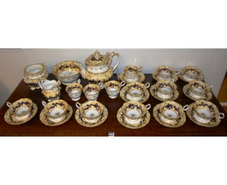 A 19th century Rockingham style porcelain tea service, decorated with cream and blue scrolls on white ground with gilded bord