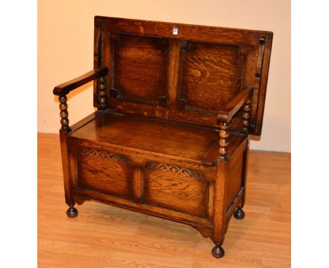 An early 20th century oak monks bench, the adjustable top raised above hinged box seat, 93cm high x 92cm wide