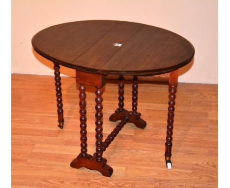 A late Victorian Sutherland table circa 1900, raised on bobbin twist supports, with ceramic castors, 52cm high, 53cm wide x 7