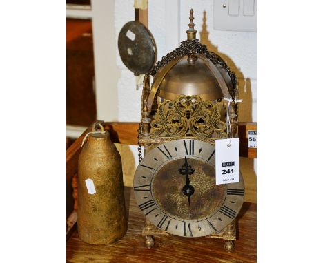 A brass lantern clock in the George II style, with silvered chapter ring  and chain attachment, with gilded weight pendulum, 