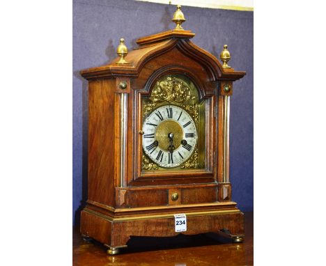 A late Victorian mahogany bracket clock, with glazed door enclosing dial with Roman numerals, decorated with gilt metal mask 