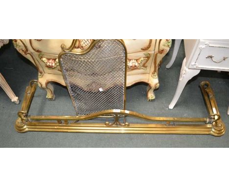 A decorative brass fender with a small brass wire work firescreen