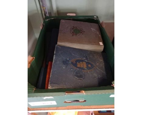 A box containing vintage postcard albums