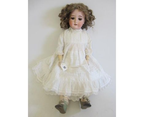 A Schoenau & Hoffmeister bisque socket head doll, with brown glass sleeping eyes, open mouth and top teeth, light brown wig, 