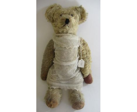 A pre-war teddy, with clear glass eyes, sewn nose, light orange plush, straw filled jointed body, long arms, humped back, fab
