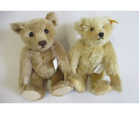 Two Steiff teddy bears, one with light orange plush, ear button and label, the other with darker plush and ear button, both a