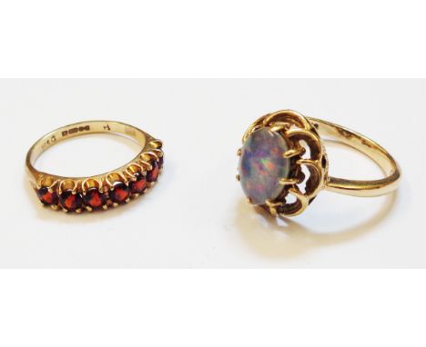 Two hallmarked 375 gold rings, one set with seven garnets, the other with doublet opal cabochon 