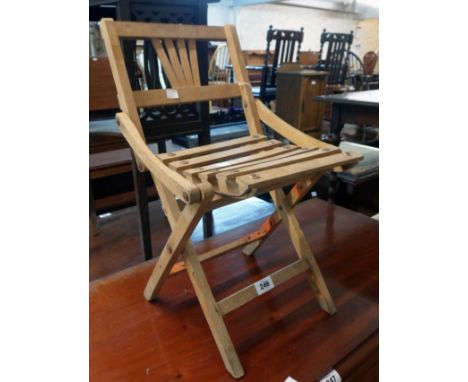 A vintage child's folding chair with slatted seat panel