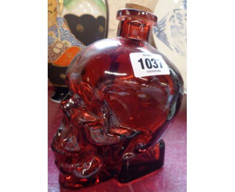 A red glass skull bottle