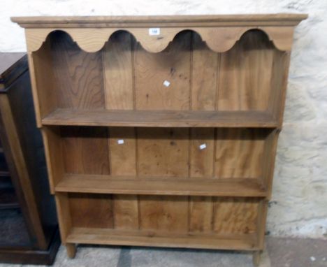 A 3' 7" wall mounted waxed elm three shelf open plate rack with moulded cornice, shaped frieze and moulded waterfall sides