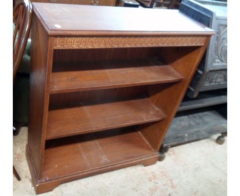 A 33" reproduction oak three shelf open bookcase with decorative moulded frieze, set on bracket feet