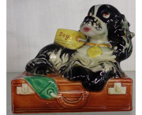 A 1957 Goebel figure of Butch the spaniel lying on a suitcase by Albert Staehle