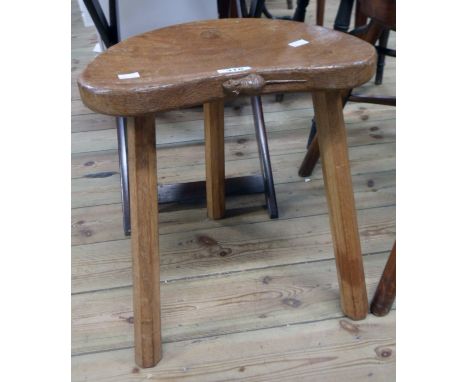 Robert "Mouseman" Thompson: a varnished oak cow stool with classic carved mouse motif to front of shaped seat panel, set on t