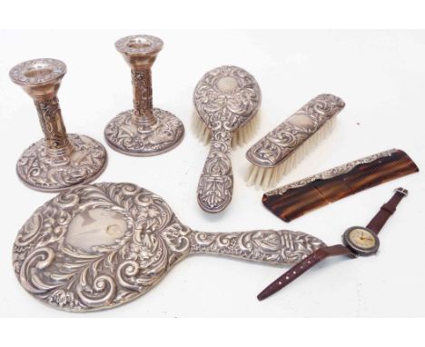 A six piece silver mounted dressing table set in the Victorian style with embossed scroll, mask and bird decoration including