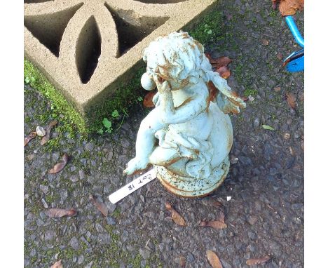 A small painted cast iron garden cherub weeping atop a finial