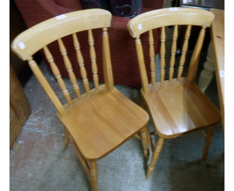A pair of modern blonde wood Windsor style kitchen chairs with solid sectional seats, set on ring turned supports