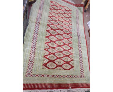 A large vintage Princess Bokhara fringe end wool rug with repeat medallion main within multi borders and bordered ends on red