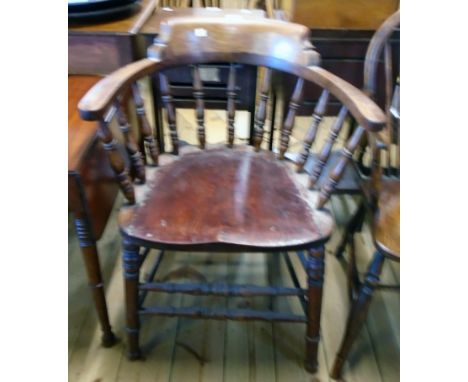 An early 20th Century stained mixed wood smoker's bow elbow chair with moulded solid seat, set on turned supports and double 