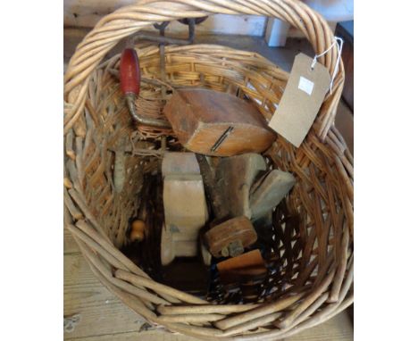 A wicker basket containing vintage tools