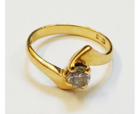 A hall marked 18ct. gold diamond solitaire cross-over ring