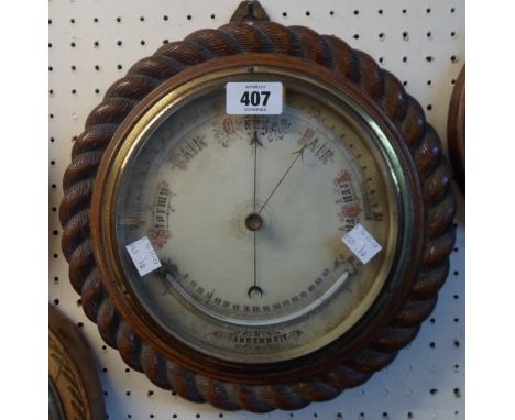 A 11 1/2" diameter Victorian carved oak rope twist border framed wall barometer/thermometer with printed dial, curved glass s