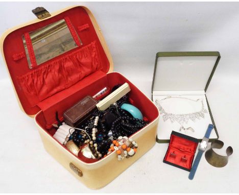 A vintage vanity case containing a quantity of costume jewellery, wristwatches and other items