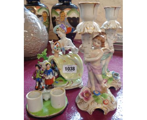 Four ceramic figures including a pair of candlesticks