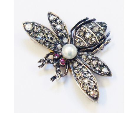 A 1 1/4" wingspan Victorian insect pattern brooch encrusted with old cut and rose diamonds, central pearl and ruby eyes