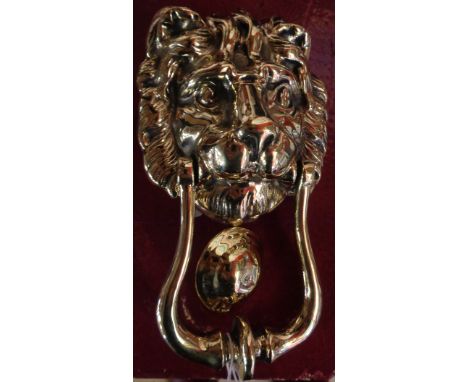 A brass lion mask door knocker